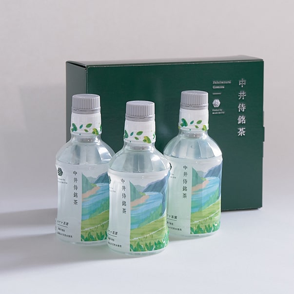 An image of three plastic bottles standing upright alongside a decorative box